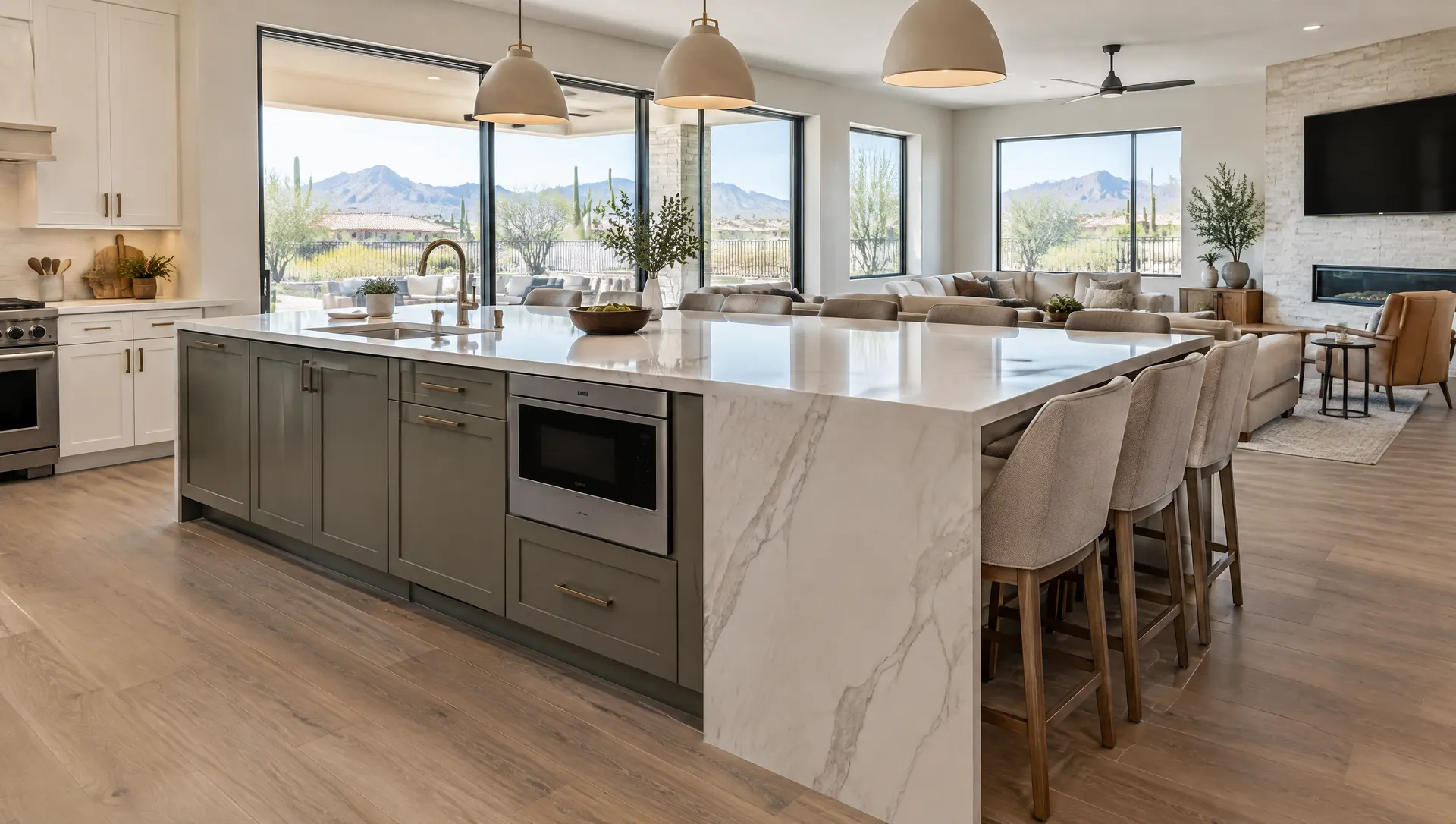 Large L-shaped kitchen island with a waterfall end, seating on two sides and a built-in microwave drawer, in an open great room